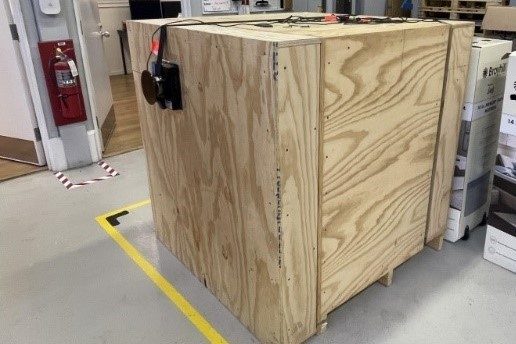 Image 3. Rigid test unit load with a length and width of 48 inches and a height of 50 ¼ inches constructed of plywood and lumber. Shows load cell located on side of unit load.